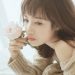 白いバラを手にしたけだるそうな女性